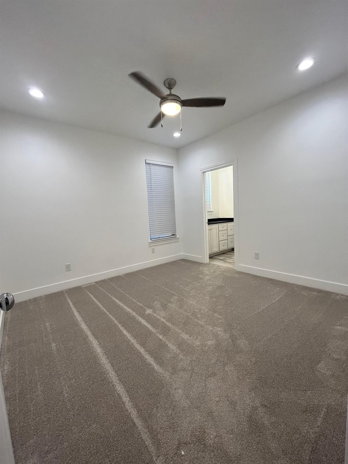 5102 58th Street, Unit 2 Lubbock, TX 79414 - Photo 12 of 18 an empty room with a ceiling fan and window