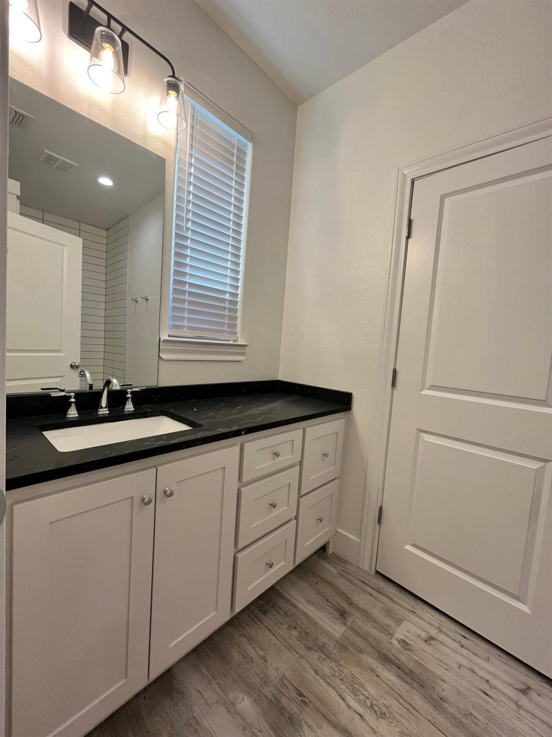 5102 58th Street, Unit 2 Lubbock, TX 79414 - Photo 13 of 18 a bathroom with a double vanity sink and mirror