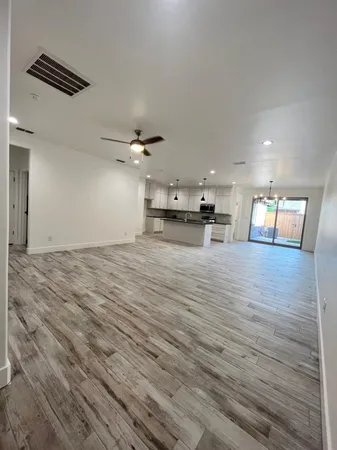 a view of kitchen with kitchen island a sink wooden floor and stainless steel appliances