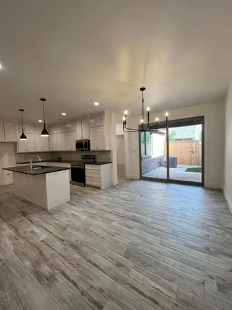a view of kitchen with stainless steel appliances granite countertop stove top oven and cabinets