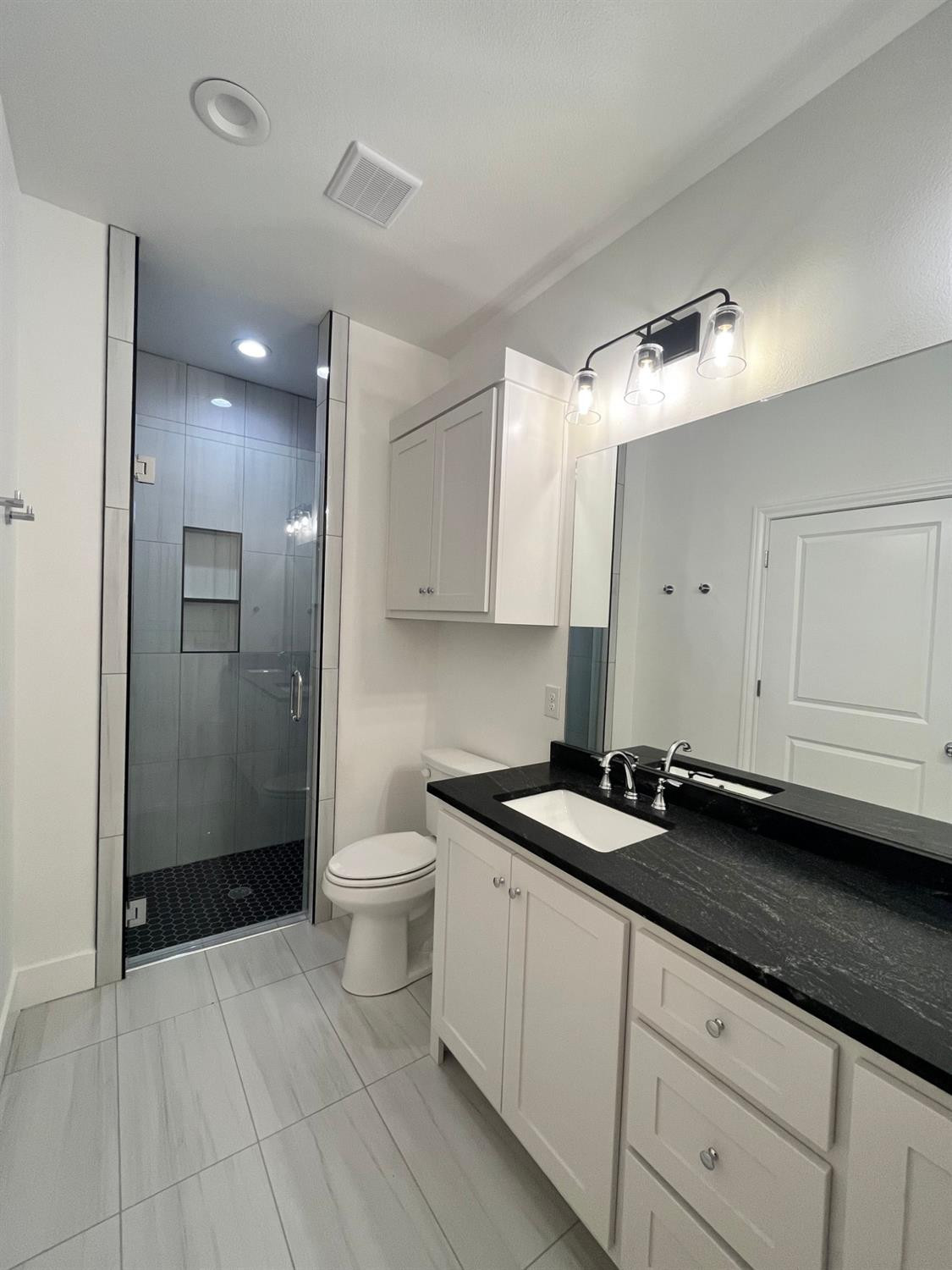 5102 58th Street, Unit 2 Lubbock, TX 79414 - Photo 10 of 18 a spacious bathroom with a granite countertop sink a toilet and shower