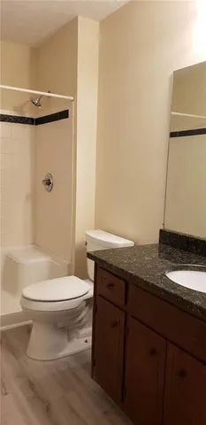 a bathroom with a granite countertop sink toilet and shower