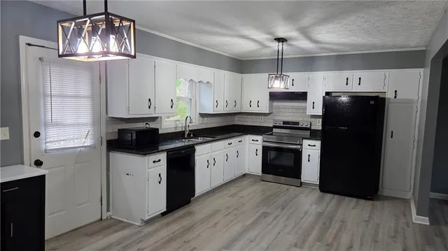 a kitchen with stainless steel appliances a stove a refrigerator a sink dishwasher a kitchen island with wooden floor and cabinets