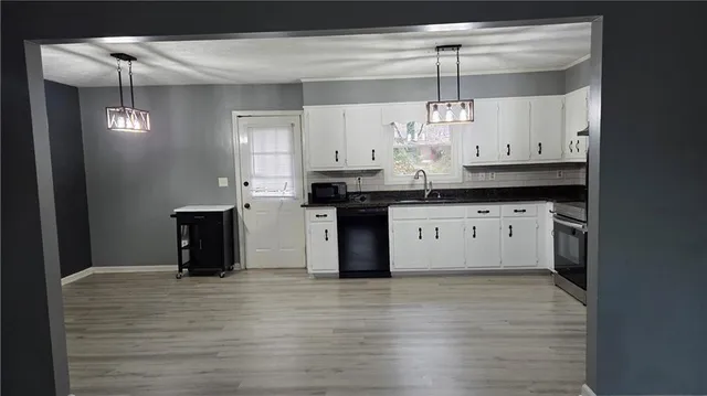 a kitchen with granite countertop a stove a sink and a refrigerator