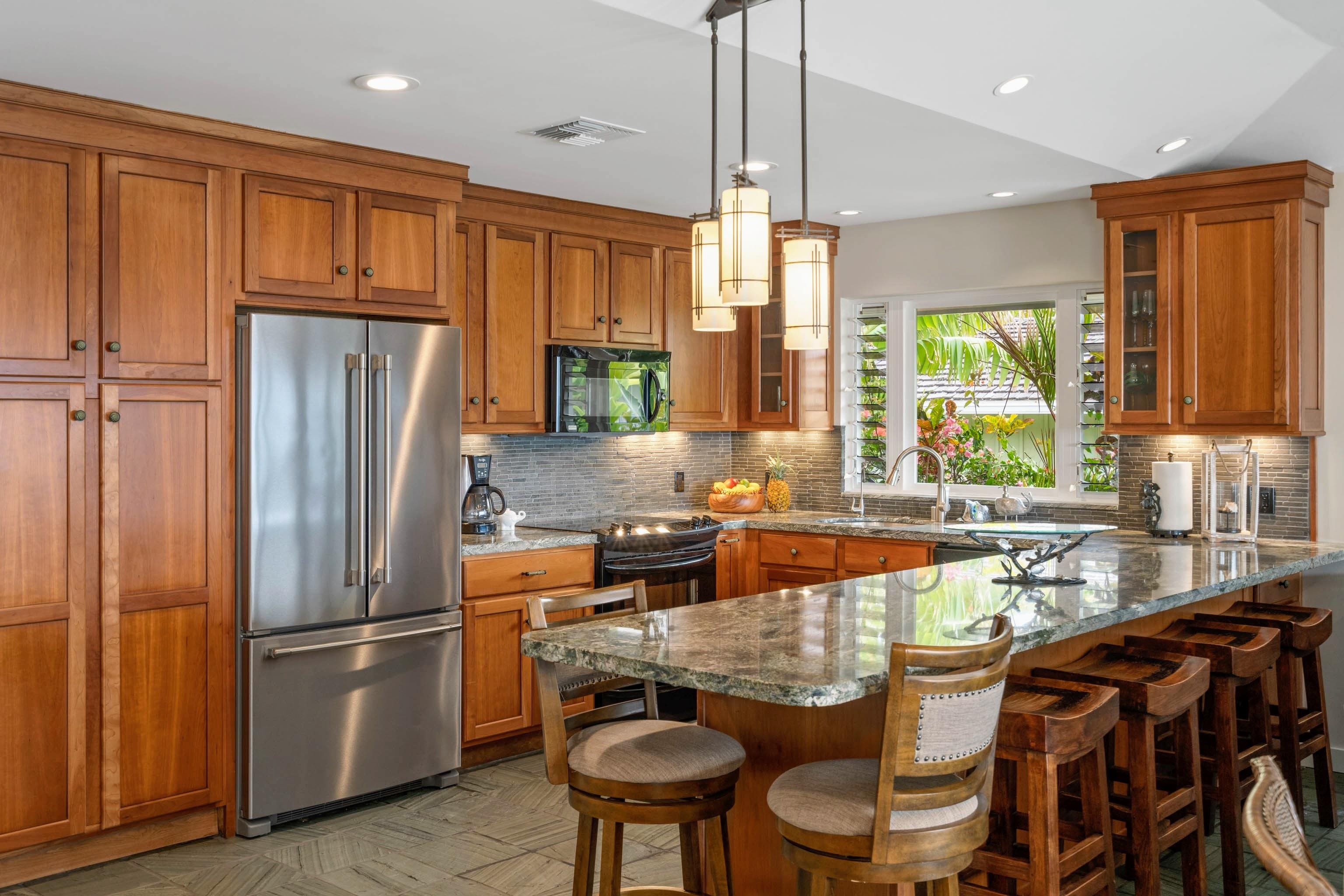 20 Hui Road East, Unit 30 Lahaina, HI 96761 - Photo 7 of 25 a kitchen with stainless steel appliances granite countertop a refrigerator a stove a sink a dining table and chairs with wooden floor