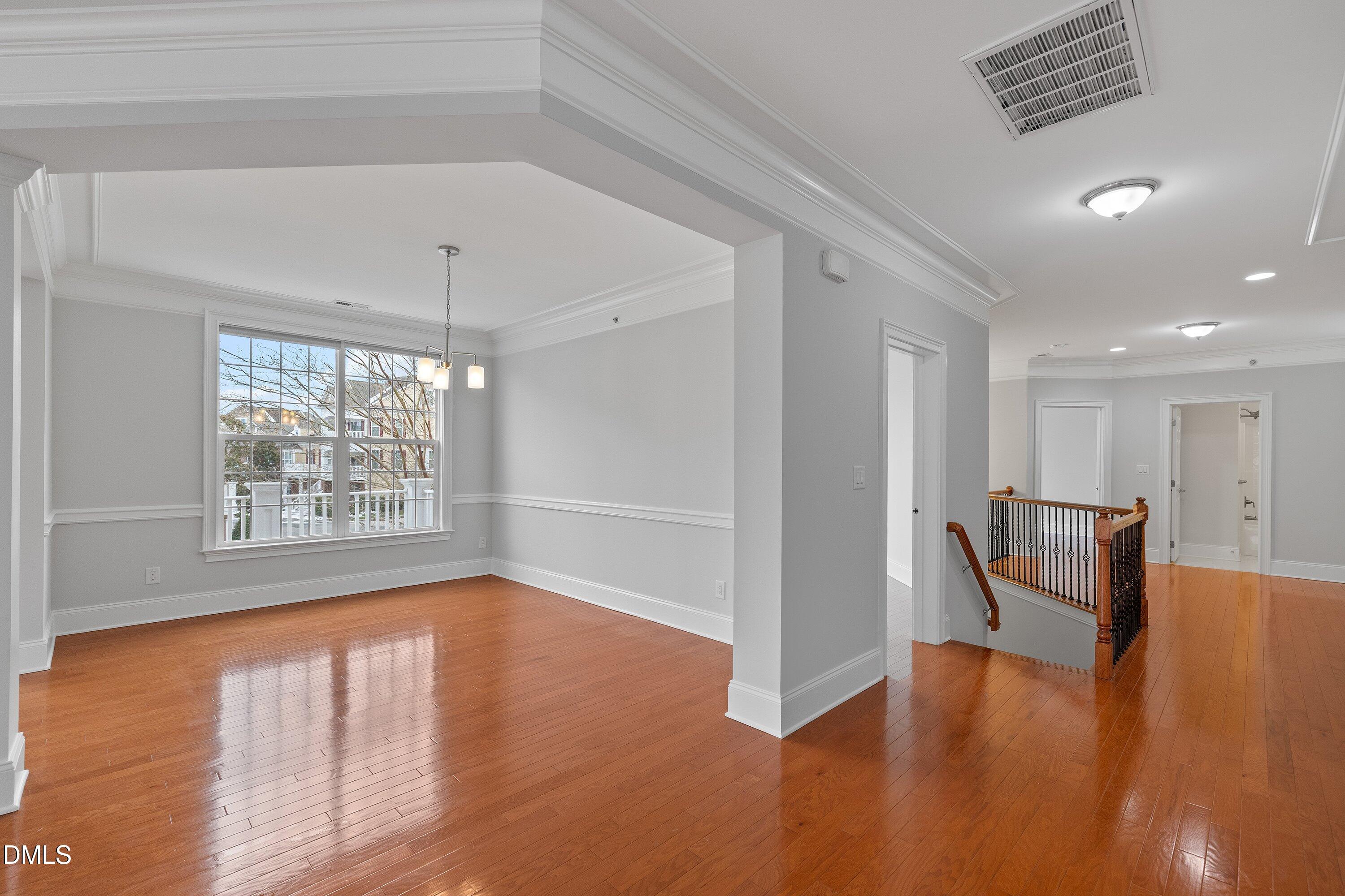 9211 Calabria Drive, Unit 205 Raleigh, NC 27617 - Photo 6 of 55 a view of an empty room with window wooden floor and a kitchen view