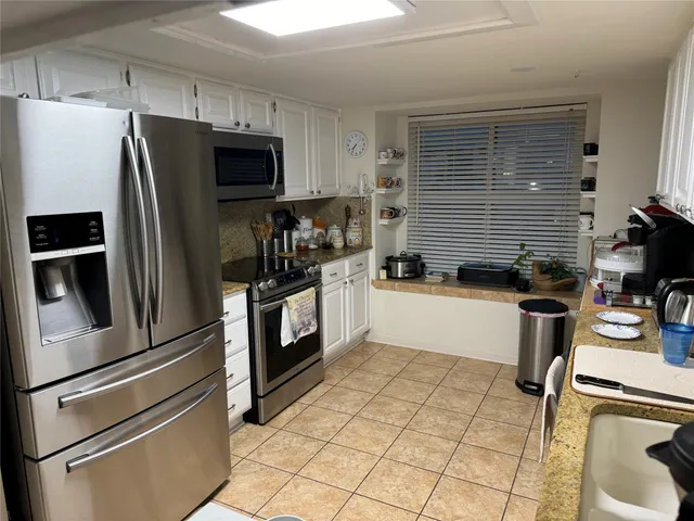 a kitchen with stainless steel appliances a refrigerator sink and cabinets