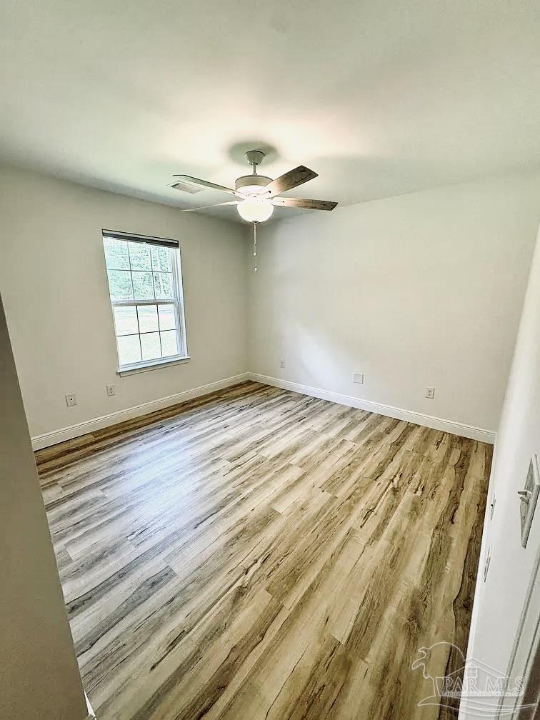 1910 West Kingsfield Road Cantonment, FL 32533 - Photo 6 of 8 an empty room with wooden floor fan and windows