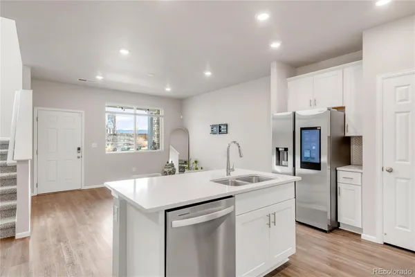 a kitchen with kitchen island a sink appliances and cabinets