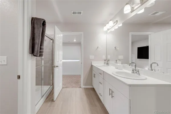 a bathroom with a double vanity sink a mirror and shower