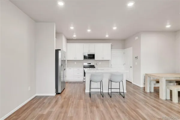 a kitchen with stainless steel appliances granite countertop a white cabinets and wooden floor