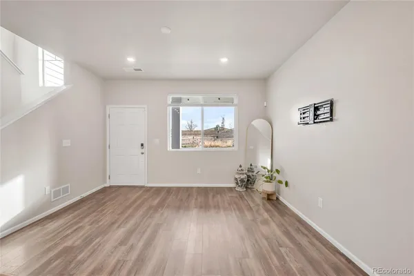 an empty room with wooden floor and windows