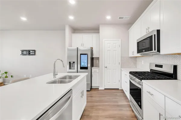 a kitchen with stainless steel appliances granite countertop a sink stove and refrigerator