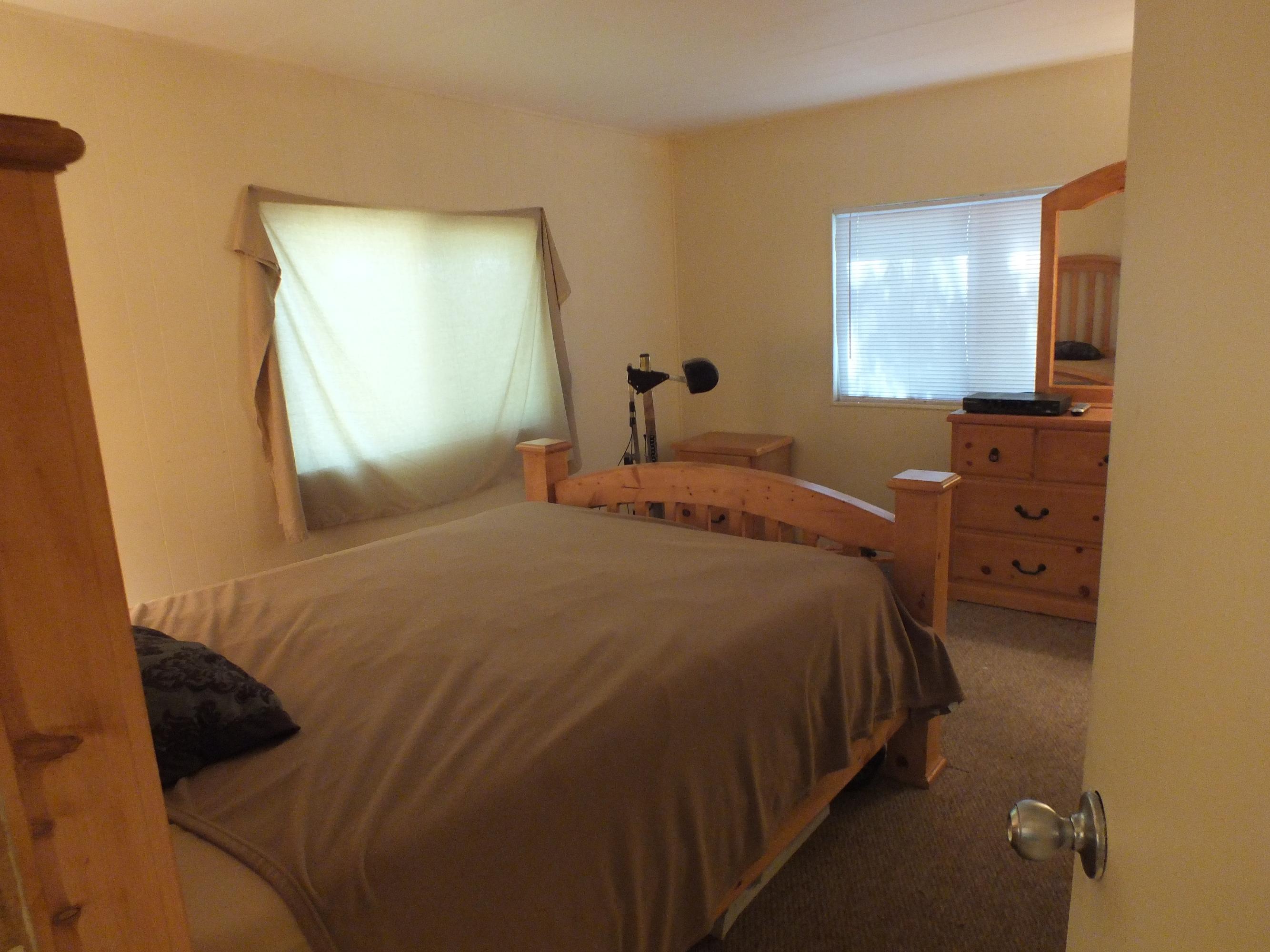 7725 Happy Valley Road, Unit DELUXE Anderson, CA 96007 - Photo 22 of 29 a bedroom with a bed and a chandelier