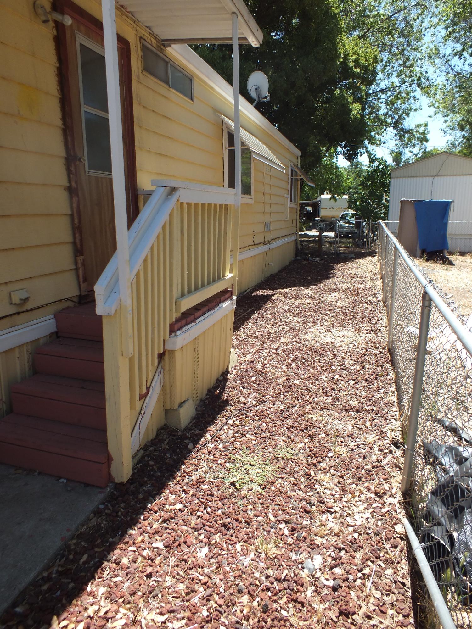 7725 Happy Valley Road, Unit DELUXE Anderson, CA 96007 - Photo 3 of 29 a view of backyard with wooden fence and large trees