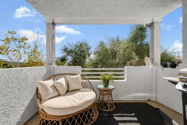 a view of a chairs and table in the balcony