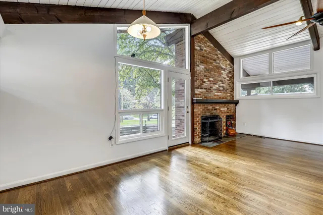 an empty room with windows and fireplace