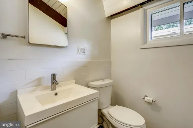 a bathroom with a sink mirror and toilet