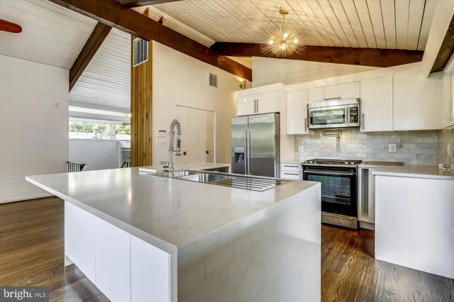 a kitchen with stainless steel appliances granite countertop a sink a stove and a refrigerator