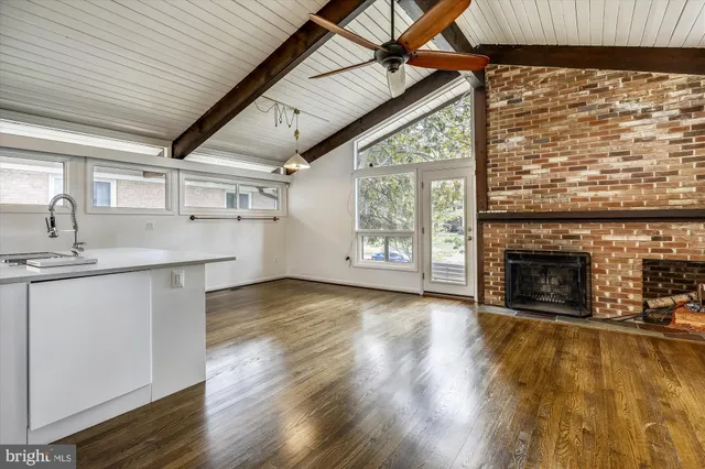 a view of a livingroom with wooden floor a fireplace and window