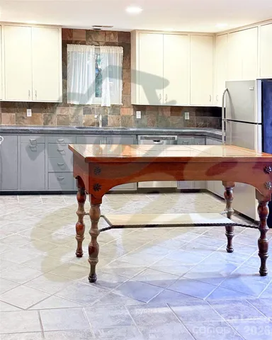 a kitchen with kitchen island a stove a sink and white cabinets