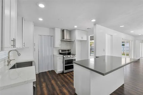 a large kitchen with stainless steel appliances granite countertop a sink a stove and a refrigerator