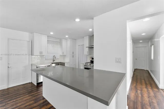 a kitchen with stainless steel appliances sink and stove top oven