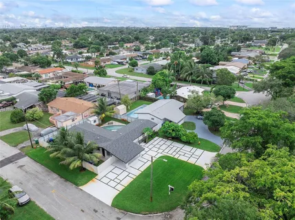 an aerial view of residential houses with outdoor space and trees