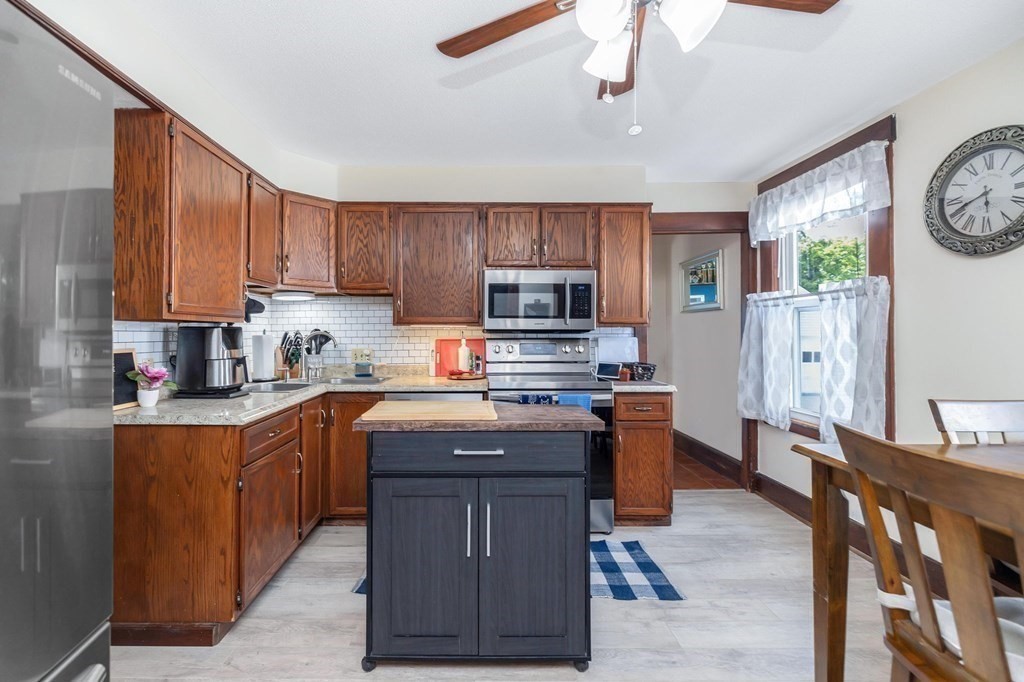 105 Pine Street West Springfield, MA 01089 - Photo 4 of 35 a kitchen with stainless steel appliances granite countertop a stove top oven a sink dishwasher and a refrigerator with wooden cabinets