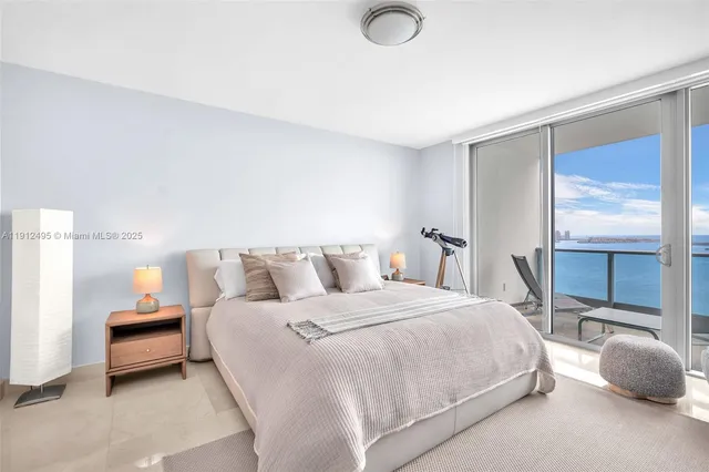 a bedroom with a bed and a large window