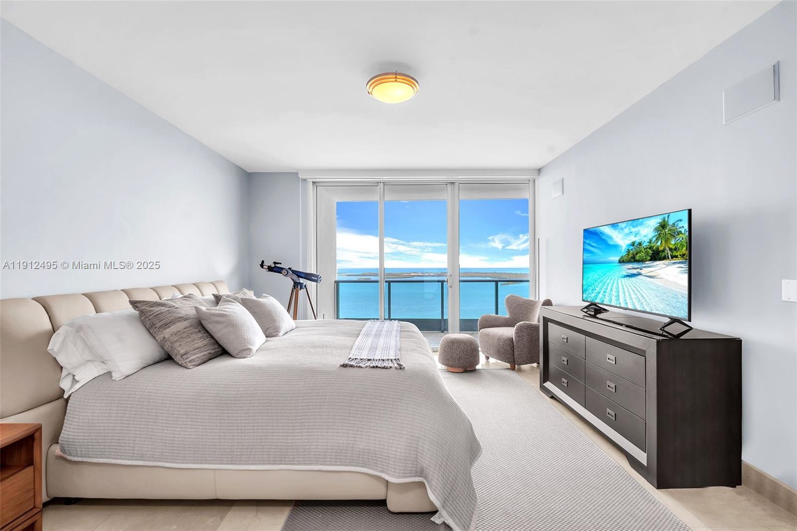 1331 Brickell Bay Drive, Unit 3609 Miami, FL 33131 - Photo 17 of 35 a bedroom with a bed and a flat tv screen on dresser