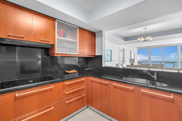 a kitchen with granite countertop a sink and a stove top oven