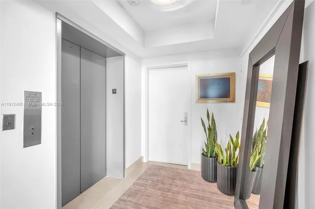 a view of a hallway with wooden floor and a living room