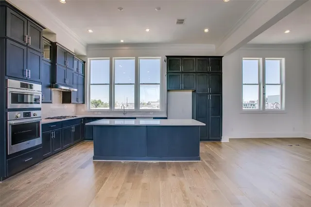 a kitchen with stainless steel appliances granite countertop a stove a sink and a refrigerator