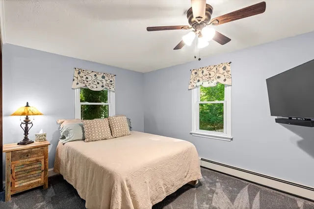 a bedroom with a bed tv and a window