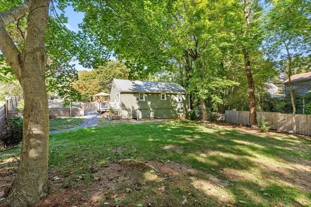 a view of a house with backyard and a tree