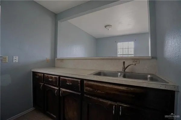 a view of a sink a counter space and cabinets