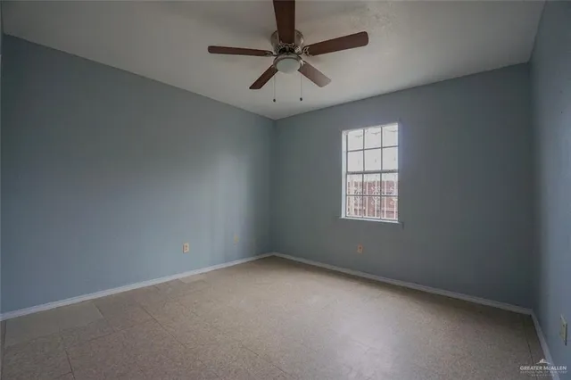 an empty room with a window and a fan
