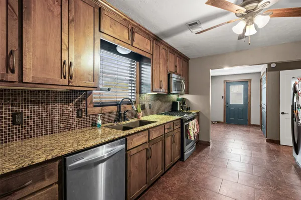 a kitchen with stainless steel appliances granite countertop a sink and cabinets