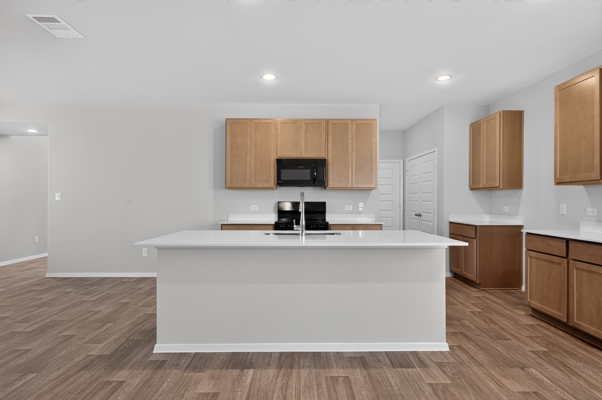 2704 Towy Road Manor, TX 78653 - Photo 31 of 36 Gleaming stone countertops and warm wood cabinetry anchor this airy kitchen workspace.