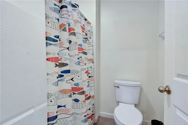 a white toilet sitting next to a shower curtain