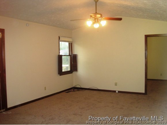1686 Rim Road Fayetteville, NC 28314 - Photo 4 of 12 an empty room with a ceiling fan and a window