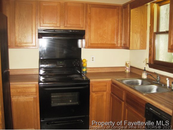1686 Rim Road Fayetteville, NC 28314 - Photo 6 of 12 a kitchen with granite countertop a stove and a sink