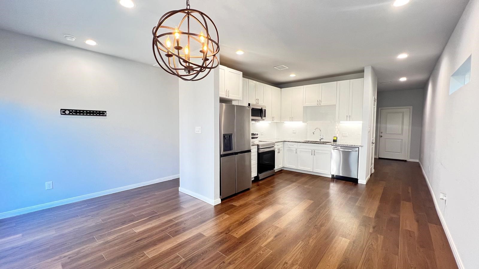4922 Dalhart Dr Spring Spring, TX 77379 - Photo 12 of 33 a kitchen with stainless steel appliances a refrigerator a oven a sink and white cabinets with wooden floor