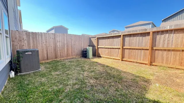 a view of a backyard with a wooden fence