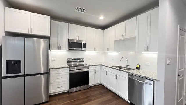 a kitchen with stainless steel appliances a refrigerator stove microwave and cabinets
