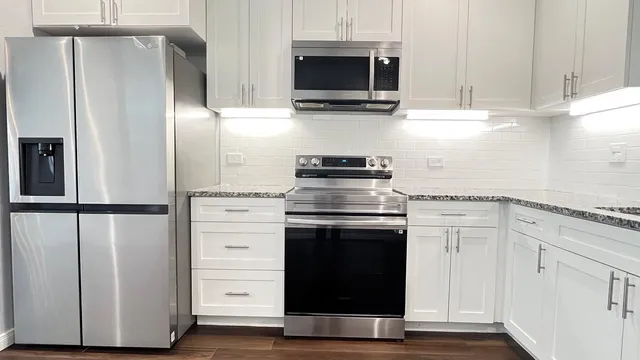 a kitchen with stainless steel appliances white cabinets and a stove