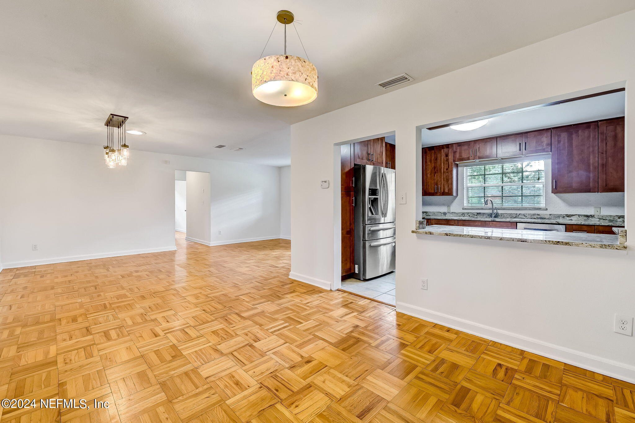 5614 Capri Road Jacksonville, FL 32244 - Photo 17 of 45 a view of kitchen and empty room with wooden floor