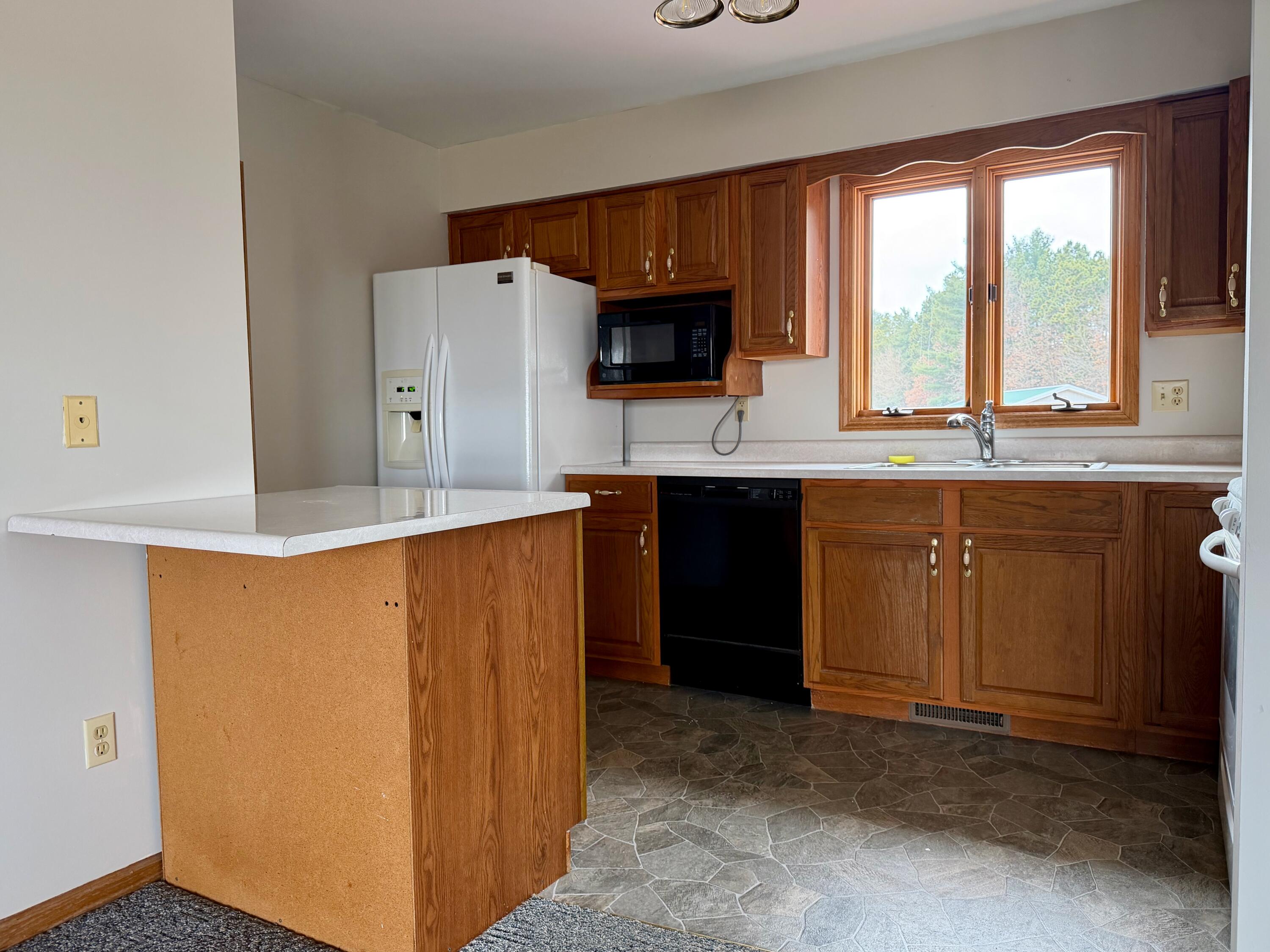 5831 West 700 North Winamac, IN 46996 - Photo 5 of 22 a kitchen with stainless steel appliances a sink a stove a refrigerator a microwave a counter top and cabinets