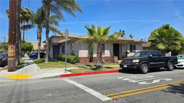a view of a white house with a swimming pool table and chairs